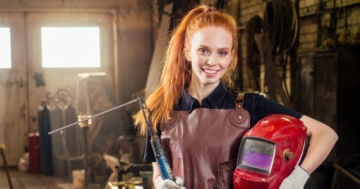 Junge Frau mit Schweißerhelm